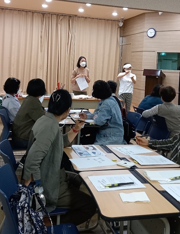 캘리그라피 강사로부터 손글씨 강의 듣는 회원분들의 모습 사진